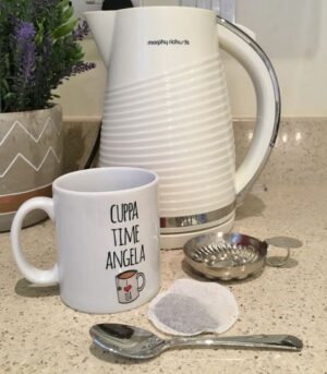 A kettle, a mug and a tea bag